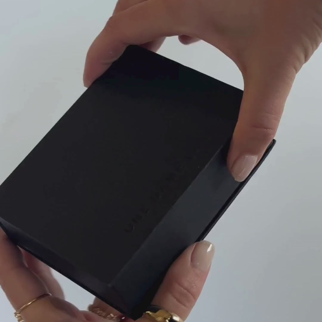 Unboxing video showing a black jewellery box, when opened there is a black pouch and white branded cards from One Dame Lane.